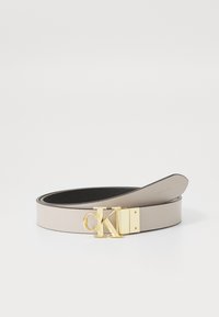Calvin Klein Gurtel aus beigem Leder mit einer goldfarbenen Logo-Schnalle. Verfügt über eine glatte Textur und ein minimalistisches Design.