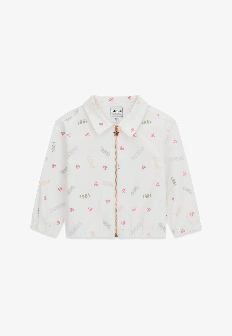 Veste blanche zippée avec col, décorée de petits cœurs roses et de mots imprimés comme "GUESS", "LOVE", "GIRL" et "1981".
