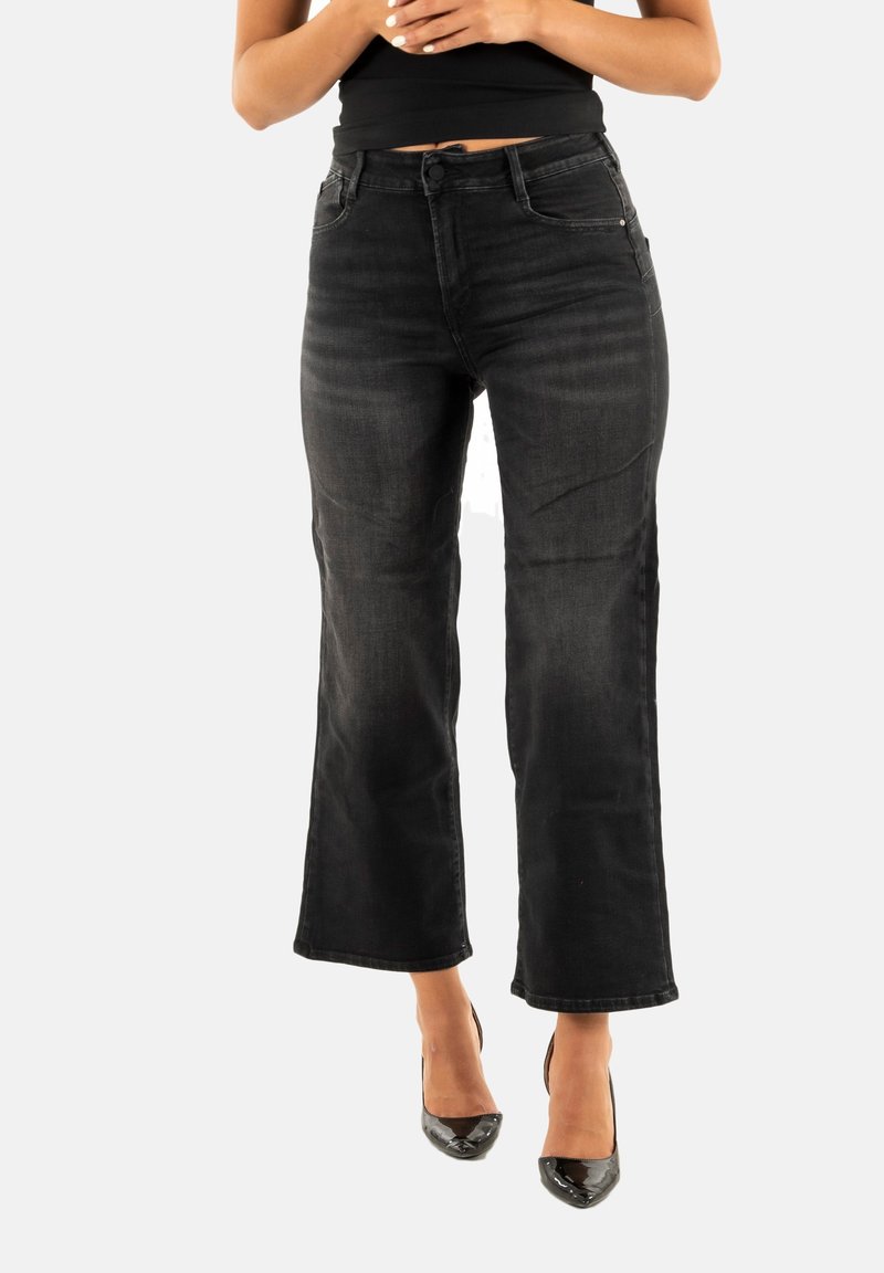 Jeans de mezclilla negra de pierna ancha con cintura a media altura, bolsillos frontales y un ligero desgastado. La tela tiene una textura suave y un estilo clásico.
