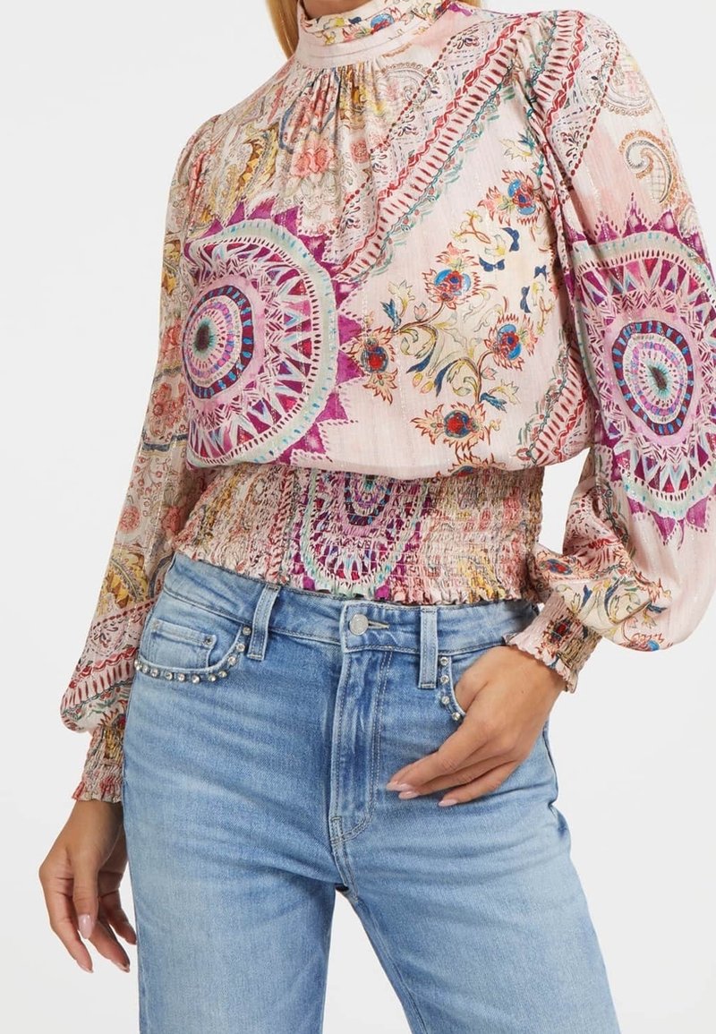Multifarvet boheme bluse med lange ærmer, høj hals og elastisk talje, der har indviklede blomster- og geometriske mønstre. Kombineret med denim.