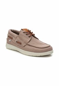 Zapato de barco de lona marrón con punta redondeada, suela de goma blanca, parte delantera con cordones y un pequeño detalle de logo en el lado.