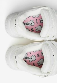 White sneakers with a textured surface, featuring a pink insole adorned with Miffy character patterns and the "miffy" logo.