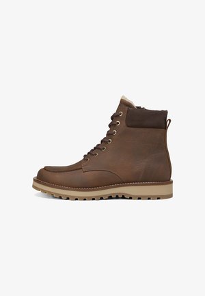 Braune Leder-Stiefel mit strukturiertem Obermaterial, sechs Metall-Ösen und Gummisohle. Mit weichem Futter und Zugschlaufe an der Ferse.