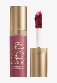 Too Faced Cloud Crush verpakking: roze container met gouden accenten, hartvormige details en een witte applicator met een pluchen punt voor lip- en wangenkleur.
