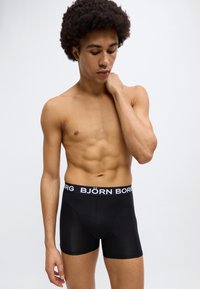 Μαύρα boxer briefs με λευκή ελαστική μέση που φέρει το λογότυπο "BJÖRN BORG". Λεία ύφασμα, εφαρμοστό σχέδιο και μήκος μέχρι το μέσο του μηρού.