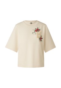 Světle béžové tričko s krátkými rukávy, zdobené květinovou výšivkou v červené a zelené barvě, s výrazným motivem písmena "B" na přední straně.