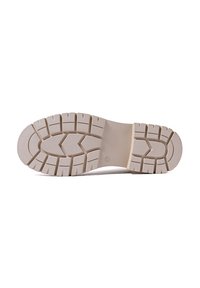 Suola di scarpa beige chiaro con profondi motivi di battistrada, dotata di una superficie testurizzata e di un design piatto e robusto. Il materiale sembra simile alla gomma per garantire aderenza.