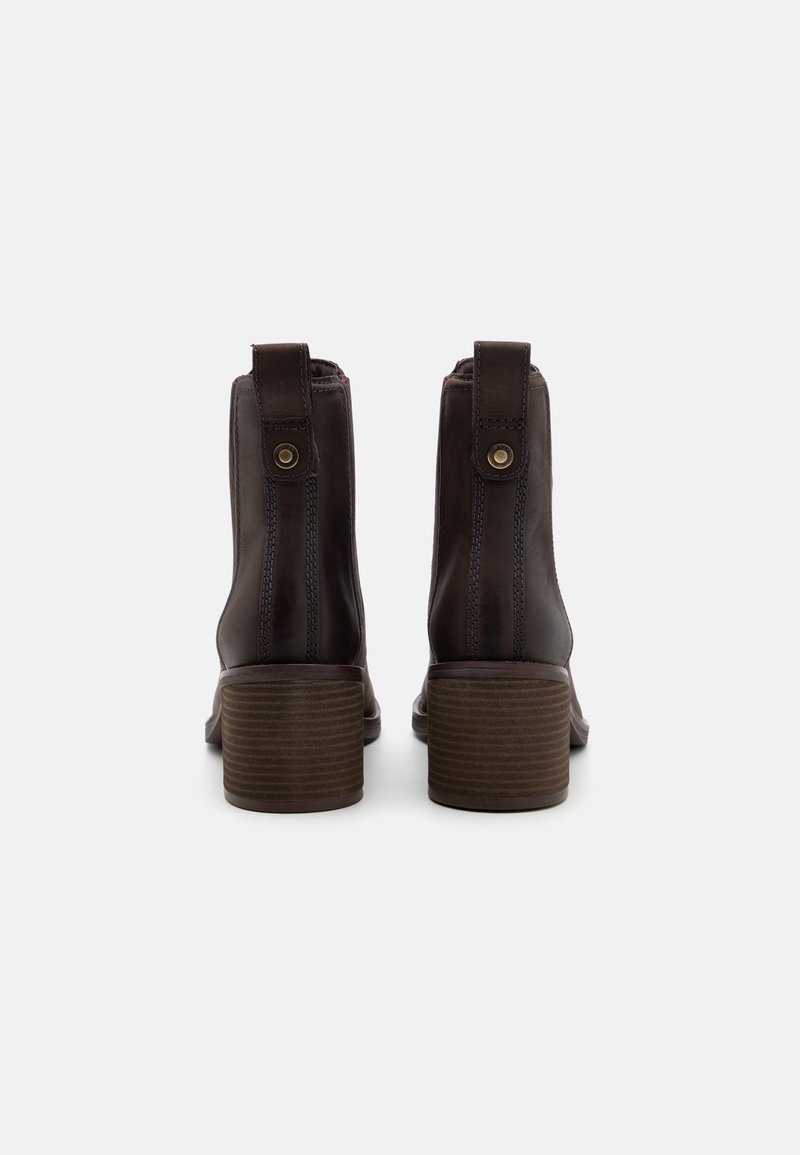 Stivaletti in pelle marrone con tacco a blocco, caratterizzati da cuciture laterali e linguette per il sollevamento, texture liscia e design della punta arrotondata.