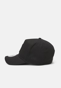 Schwarze Kappe mit gebogenem Schirm, aus Baumwollstoff. Verfügt über ein strukturiertes Logo an der Seite und ein dekoratives Etikett auf der Rückseite.