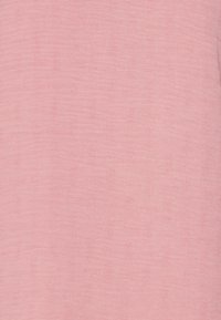 Mjukt rosa tyg med ett subtilt vävt mönster av små rektangulära former som skapar en texturerad design.