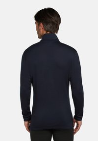 Dunkelblaues Langarm-Polohemd mit Stehkragen. Glattes, strukturiertes Gewebe, das eine taillierte Silhouette und einen leicht abgerundeten Saum am Rücken aufweist.
