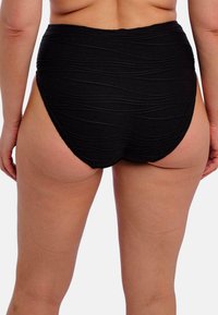 Vysoké černé plavkové kalhoty s texturovanými, vlnitými detaily, vyrobené z elastického materiálu a s poloodhaleným designem vzadu.