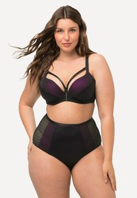 Ensemble de lingerie noire avec un soutien-gorge présentant des détails rayés violets et des bretelles ajustables, associé à des bas taille haute noirs avec des accents à motifs.