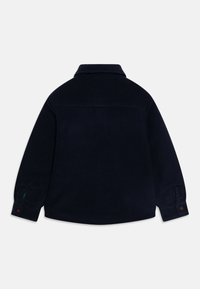 Dark navy fleece shirt with a collar, long sleeves, and button cuffs. Soft texture with a single back pocket detail.