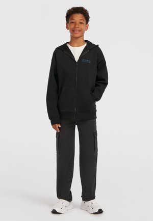 Black zip-up hoodie with front pockets and blue logo, paired with black cargo pants featuring side pockets and white sneakers.