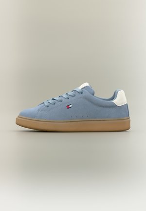 Adidași din piele întoarsă bleu deschis, cu o garnitură albă pe călcâi și șireturi asortate, prevăzuți cu talpă de gumă și mici orificii de ventilație pe părțile laterale.