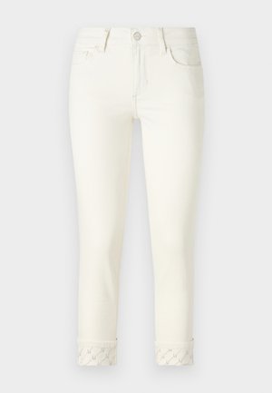 Jeans in denim bianco con un design aderente, stile a cinque tasche e orli arrotolati con una sottile rifinitura a fantasia. Girovita standard e cuciture.