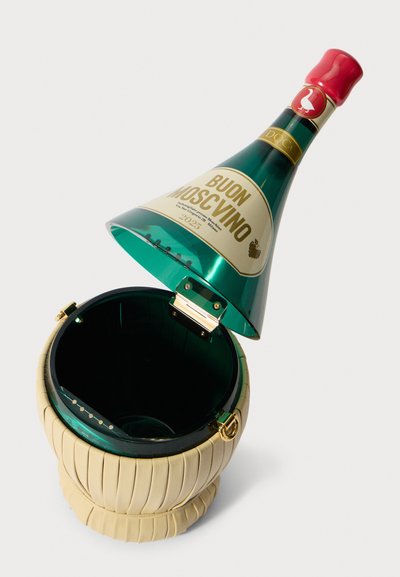 Grøn, gennemsigtig vinflaske-formet isspand med en tekstureret, cremet beige bund og guldhardware, åben for at afsløre sin indvendige del.