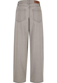 Pantalones grises de pernera ancha hechos de denim suave, con una cintura alta, que presentan una etiqueta de cuero en la parte trasera y dos bolsillos en la parte posterior.