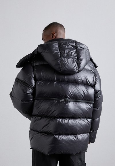 Doudoune en matériau noir brillant, dotée d'une capuche amovible, d'un design matelassé et de poches zippées sur les côtés.