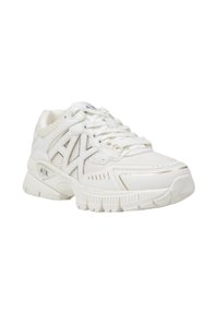 Sneaker atletica bianca in materiale mesh e sintetico, con logo prominente, colletto imbottito e suola testurizzata. Presenta sottili accenti dorati.