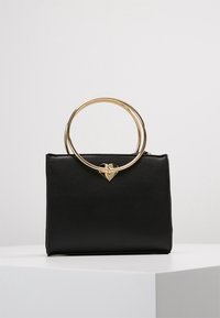 Svart fusk läderhandväska med en strukturerad design, gyllene rund handtag och en hjärtformad detalj på framsidan. Slät textur.