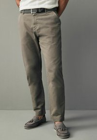 Khaki chinos o prostym kroju, z bawełny, z płaskim przodem i lekkim blaskiem. Połączone z szarymi mokasynami z detalem w postaci frędzli.