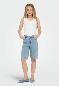 Gaiši zili džinsi īsie šorti ar ziedu izšuvumu, augstas jostasvietas dizains un aplokšņu apakšdaļa, saskaņoti ar baltu bezpiešu topu.