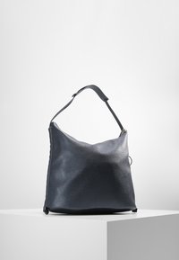 Black textured leather shoulder bag with a curved shape, a single adjustable strap, and minimalistic gold hardware detail.