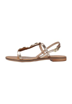 Sandalias planas con correas en metálico dorado, diseño de punta abierta, hebilla ajustable en el tobillo y plantilla y suela de cuero marrón.