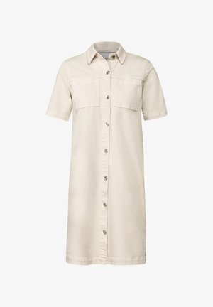 Un vestido camisero de color beige claro hecho de una tela suave, con mangas cortas, dos bolsillos en el pecho y un cierre frontal de botones. Diseño simple y recto.