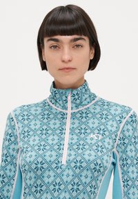 Μπλε βασικό στρώμα με φερμουάρ, διακοσμημένο με γεωμετρικό σχέδιο νιφάδας χιονιού, μαλακή υφή, αντίθετη ροζ ραφή και σχέδιο με ψηλό γιακά.