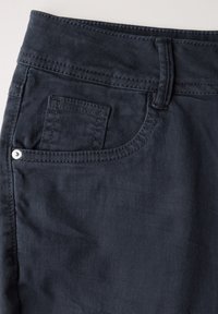 Pantalones vaqueros de mezclilla gris oscuro con una textura suave, que presentan un bolsillo frontal y costuras sutiles en la cinturilla y los bordes del bolsillo.