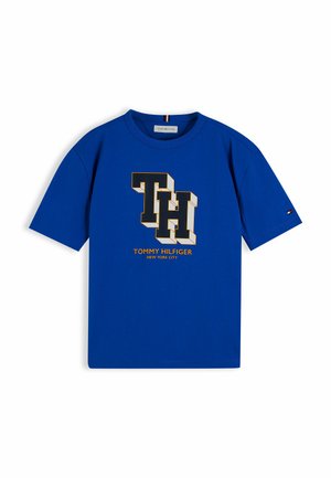 Blå t-shirt med korte ærmer med store 3D-stil "TH" bogstaver og "Tommy Hilfiger New York City" tekst i gul nedenunder.