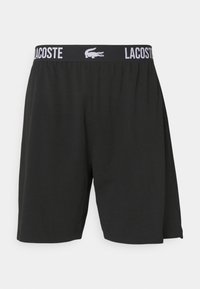 Shorts noirs avec une taille élastique affichant le texte et le logo blanc "LACOSTE". Fabriqués en tissu lisse, avec une coupe ample et sans poches.