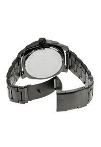Montre en acier inoxydable noir avec une finition mate, dotée d'un boîtier rond, d'un bracelet texturé et d'un fermoir pliant. Le dos affiche les informations du modèle.