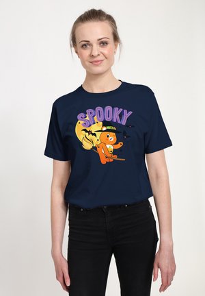 Mørkeblå t-shirt med et tegneserie-bjørn på en kost, med "SPOOKY" i lilla tekst og en gul månebaggrund. Korte ærmer, lavet af bomuld.