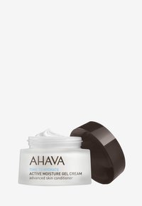AHAVA Active Moisture Gel Cream i klar burk med svart lock; slät, vit gel synlig. Etikett med brun och blå text. Minimalistisk design.