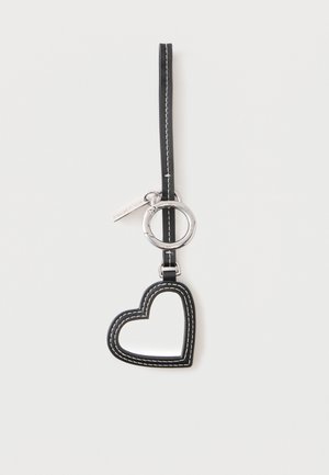 Porte-clés en cuir noir en forme de cœur avec des coutures blanches, attaché à une lanière noire et un anneau métallique argenté.