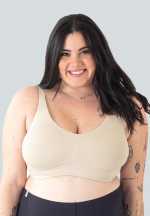 Reggiseno beige con spalline larghe, texture liscia e design a scollatura arrotondata. Spalline regolabili e minimi dettagli in metallo.