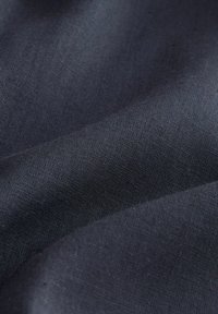 Țesătură gri închis cu un finisaj neted, texturat. Materialul este ușor și ușor lucios, având un model subtil țesut.