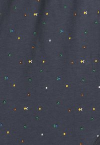 Granatowa bawełniana tkanina z wielokolorowymi geometrycznymi wzorami w odcieniach zieleni, żółci, pomarańczy, niebieskiego i bieli, równomiernie rozmieszczonymi na powierzchni.