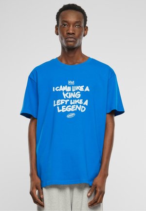 Blå bomulds T-shirt med rund hals, korte ærmer og hvid grafisk tekst: "JEG KOM SOM EN KONGE, FORLADTE SOM EN LEGEND" på forsiden.