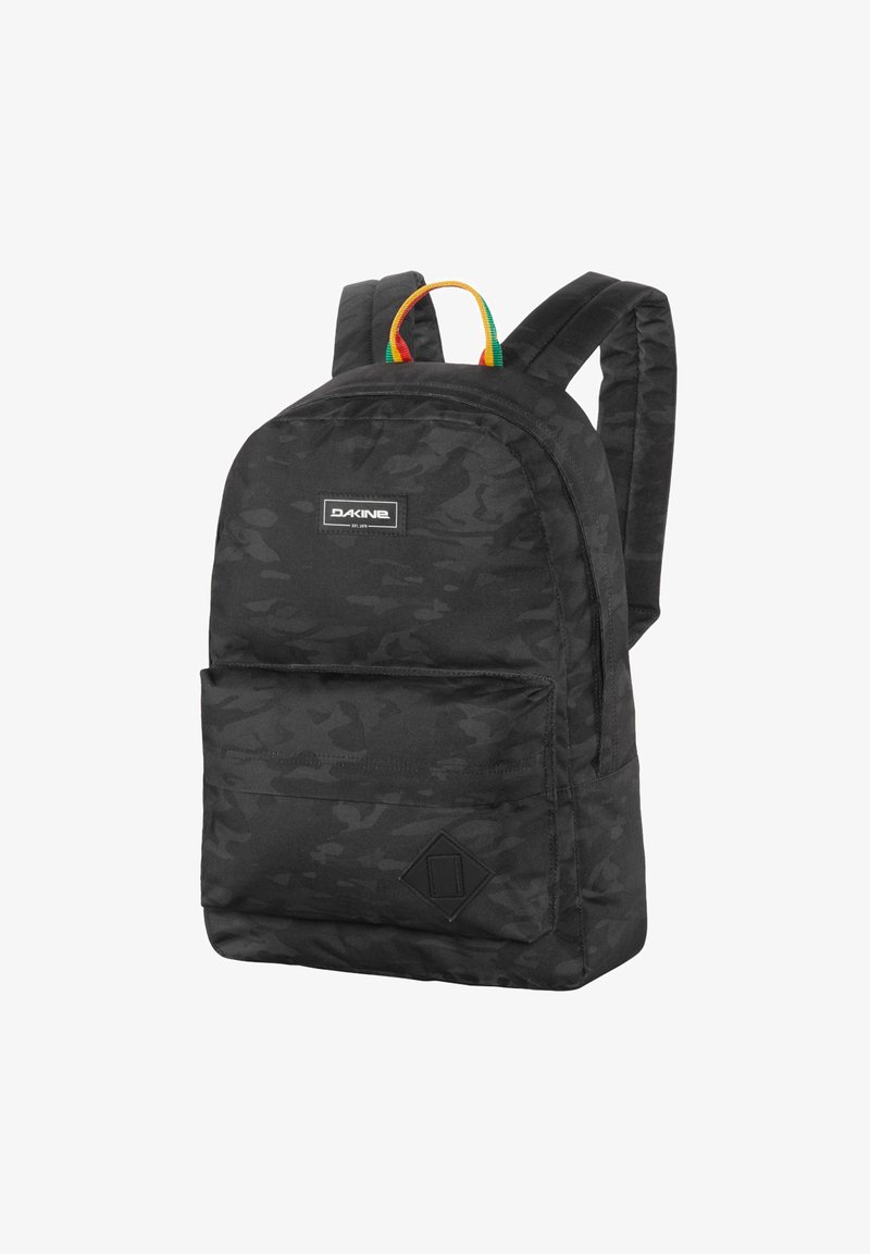 Mochila de camuflaje negra con correas acolchadas, bolsillo frontal y un asa superior colorida. Presenta un parche con logo y tela texturada.