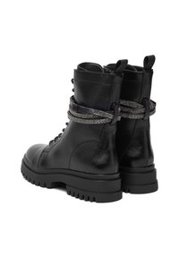 Czarne skórzane buty wojskowe z grubymi podeszwami z bieżnikiem i dekoracyjnymi paskami z cyrkoniami owiniętymi wokół kostek.