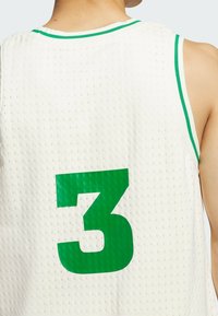 White mesh basketball jersey featuring a green collar and the number 3 in a bold green font on the back. Textured fabric with ventilation holes.
