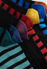 Seks par sorte sokker med lyse farvede tæer og striber: blågrøn, marineblå, lilla, rød, gul, blå og brun.