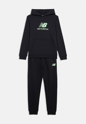 Czarny zestaw bluz i spodni dresowych New Balance z jasnozielonym logo na klatce piersiowej i lewym udzie, wyeksponowany na białym tle.