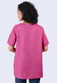 Short-sleeved top in solid pink linen blend with a round neckline, side pockets, and a relaxed fit, extending to mid-hip.