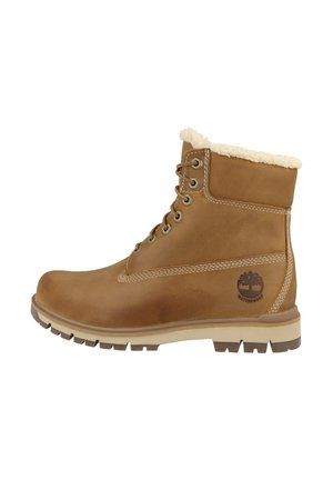 Laarzen van tankleurig leer met veters, een kraag van schapenvacht, een robuuste zool en een waterdicht Timberland-logo aan de zijkant.